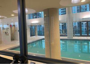 a swimming pool in a building with a large window at Toronto downtown Fort York suites 1BDRM with parking in Toronto