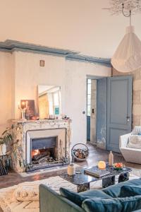 a living room with a fireplace and a couch at La Nuit & Le Jour in Vertheuil-en-Médoc
