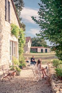 een groep mensen die buiten een gebouw in stoelen zitten bij La Nuit & Le Jour in Vertheuil-en-Médoc