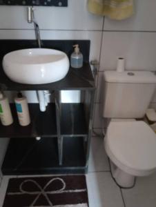 ein Badezimmer mit einem weißen WC und einem Waschbecken in der Unterkunft Casa Para Temporada - Cantinho da Cida in Serra