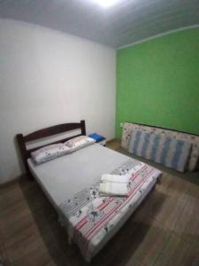 1 Schlafzimmer mit 2 Betten in einem Zimmer mit grünen Wänden in der Unterkunft Casa Para Temporada - Cantinho da Cida in Serra