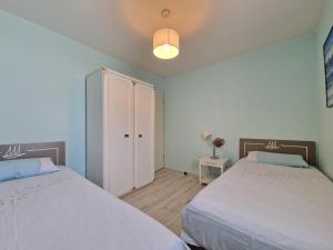 a bedroom with two beds and a white cabinet at Appartement avec Piscine, Tennis & Balcon, Centre-ville Chatelaillon-Plage, 6 Pers, 2 Ch - FR-1-706-17 in Châtelaillon-Plage +8 photos