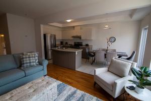 ein Wohnzimmer mit einem Sofa und einer Küche in der Unterkunft Executive 3 Bedroom townhouse close to the Lake in Hamilton