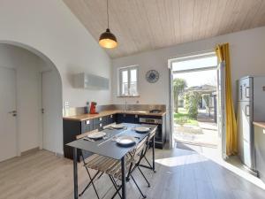eine Küche mit einem Tisch und Stühlen in der Unterkunft Maison rénovée avec piscine, jardin clos et terrasse, à 5 min de la plage et des commerces - FR-1-706-5 in Châtelaillon-Plage