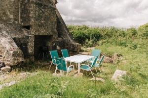 einen Tisch und Stühle vor einem Gebäude in der Unterkunft Kitts Cottage Rural, Woodburner, King Size Bed in Redruth