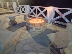 a fire pit on a patio next to a fence at Pousada Chalés Vale Sereno in Camanducaia