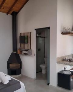 a bedroom with a bed and a sink and a toilet at Chalés Vale Sereno in Camanducaia