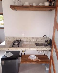 a small kitchen with a sink and a stove at Chalés Vale Sereno in Camanducaia