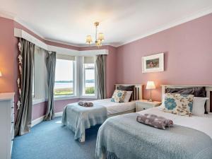 a hotel room with two beds and a window at 4 Bed in Lamlash CA369 in Lamlash