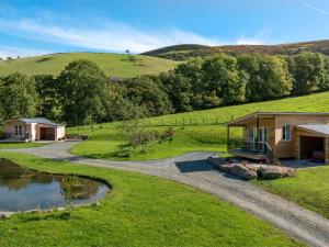 a house on a hill next to a pond at 1 Bed in Builth Wells BN089 in Garth