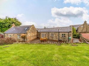 an exterior view of a stone house with a yard at 3 Bed in Longhoughton 88231 in Long Houghton