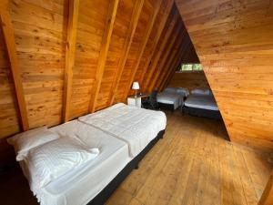 a bedroom with a bed in a room with wooden walls at Lovely two bedroom cabin on avocado farm in Marinilla