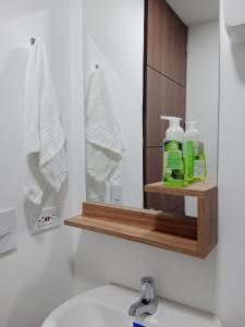ein Badezimmer mit einem Waschbecken, einem Spiegel und Handtüchern in der Unterkunft Apartamento Nuevo - Centro Internacional Bogotá in Bogotá