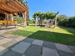 um jardim com uma mesa de piquenique e um gazebo em Casa en Olmué em Olmué