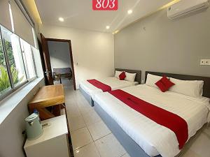 una camera d'albergo con due letti e una finestra di VND Vũng Tàu Hotel & Villa a Vung Tau