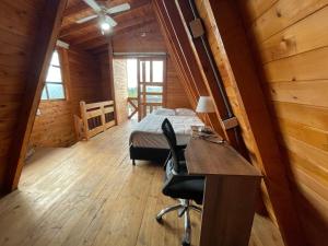 a bedroom with a bed and a desk in a cabin at Lovely two bedroom cabin on avocado farm in Marinilla