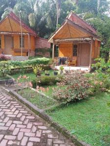 a house with a garden with flowers in the yard at Orchid Bugalows. in Timbanglawang