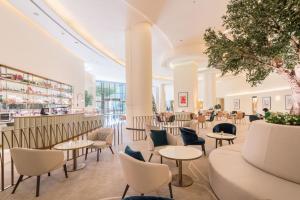 a lobby with tables and chairs and a bar at JW Marriott Hotel Marina in Dubai