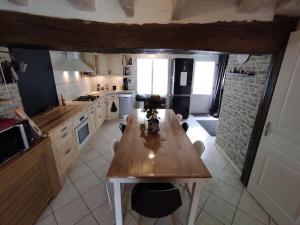 uma cozinha com uma mesa de madeira em Chaleureuse maison de ville avec parking gratuit em Chinon
