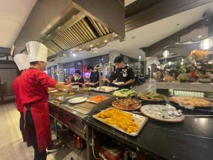 un gruppo di chef che preparano il cibo in una cucina di Lotus Aroma Sapa Hotel a Sa Pa