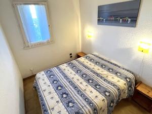 een slaapkamer met een bed en een raam bij Appartement Cap d'Agde, 3 pièces, 6 personnes - FR-1-769-4 in Cap d'Agde