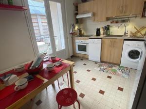 eine Küche mit einem Tisch und einer Waschmaschine in der Unterkunft Charmant 3 pièces au cœur de Villard-de-Lans avec Wi-Fi - FR-1-515-195 in Villard-de-Lans + 9 Fotos