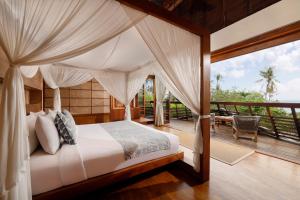 um quarto com uma cama de dossel e um deque em The Cove Bali by Nakula em Balian