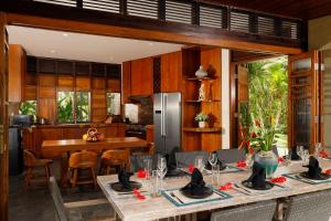 uma cozinha e sala de jantar com mesas e cadeiras em The Cove Bali by Nakula em Balian