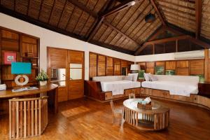 a large bedroom with two beds and a table at The Cove Bali by Nakula in Balian