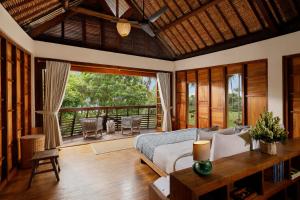um quarto com uma cama e uma varanda em The Cove Bali by Nakula em Balian