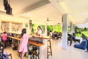 a group of people standing at a counter in a restaurant at Hotel Bonne Nuit in Labuan Bajo
