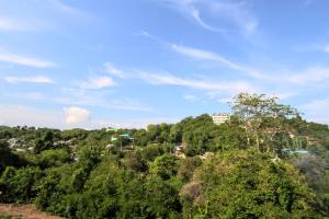 a view of a hill with trees and buildings at Hotel Bonne Nuit in Labuan Bajo