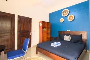 a blue bedroom with a bed and a blue wall at Hotel Bonne Nuit in Labuan Bajo