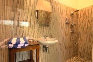 a bathroom with a sink and a shower at Hotel Bonne Nuit in Labuan Bajo