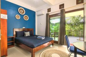 a bedroom with a bed and a balcony at Hotel Bonne Nuit in Labuan Bajo +8 photos