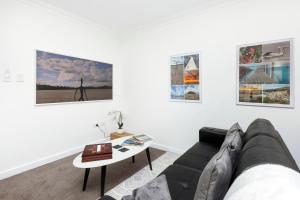 a living room with a couch and some pictures on the wall at City View 1br Gem On Mounts Bay Road in Perth