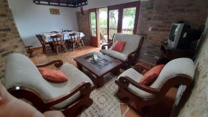 a living room with chairs and a tv and a table at Finca el Fical in Coper