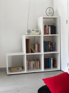 a white book shelf filled with books in a room at Petite halte O Cœur des Ilets in Bouillante