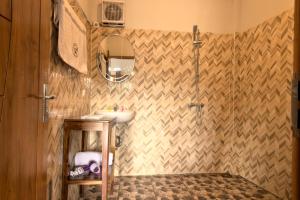 a bathroom with a sink and a shower at Hotel Bonne Nuit in Labuan Bajo
