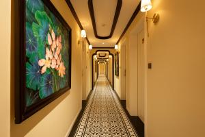 einen Korridor in einem Gebäude mit einem Gemälde an der Wand in der Unterkunft Stella Marina Boutique Hotel in Phu Quoc