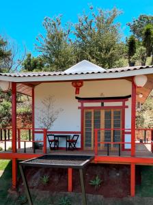a small house with a patio and a table at Mundarium - Chalés Temáticos com Hidromassagem e Cromoterapia in Santo Antônio do Pinhal
