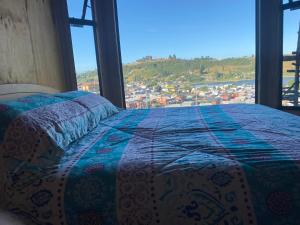 a bed in a room with a view of a city at Casa familiar Jocelyn in Castro