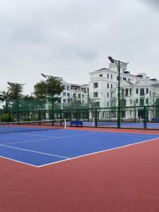 a tennis court with buildings in the background at Vinhomes Marina in Xóm Niêm