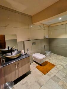a bathroom with a sink and a toilet at Kuruva Island Resort And Spa - By KABINI BREEZE, Wayanad in Mananthavady