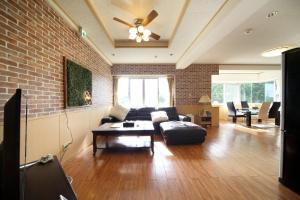 a living room with a couch and a brick wall at Green Garden Hills 3F-2 in Okinawa City