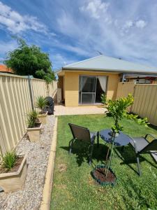 a backyard with a table and chairs and a fence at Queen bed apartment- No sharing, your very own space in Quinns Rocks