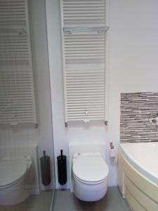 een badkamer met een toilet, een wastafel en een bad bij Loft in Antwerpen