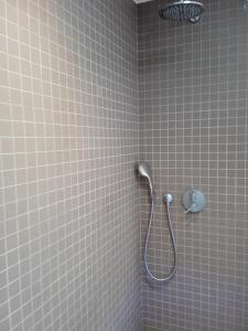 een betegelde douche met een douchekop in de badkamer bij Loft in Antwerpen