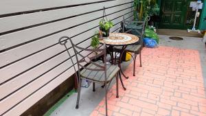 two chairs and a table with plants on a brick patio at HILDA INN in Kashiwa