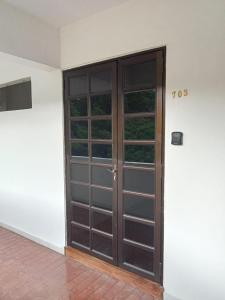 a large wooden door with windows in a room at Batu Feringgi Sri Sayang Apartment in Batu Ferringhi